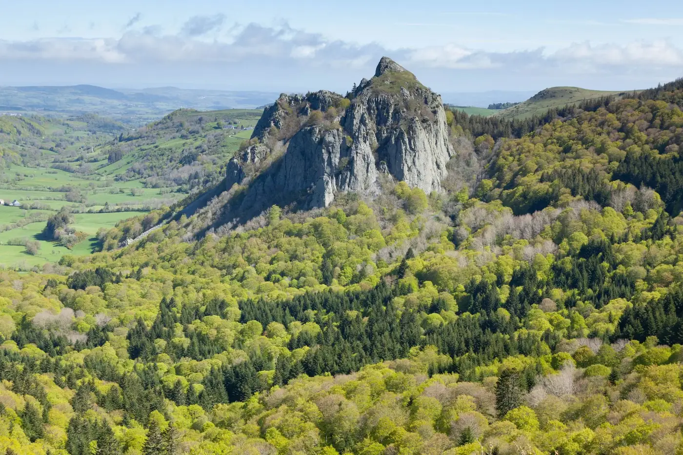 Breathtaking view of Mont-Dore landscape with lush hills and mountains in spring.