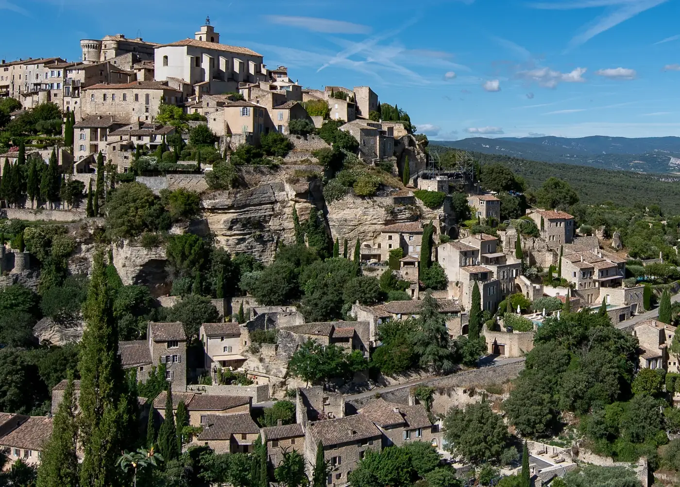 Picturesque hillside village of Gordes in Provence, showcasing historic architecture and lush greenery.