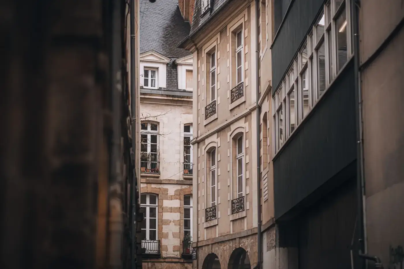 Explore the quaint architecture of a historic European city through this narrow alley view.