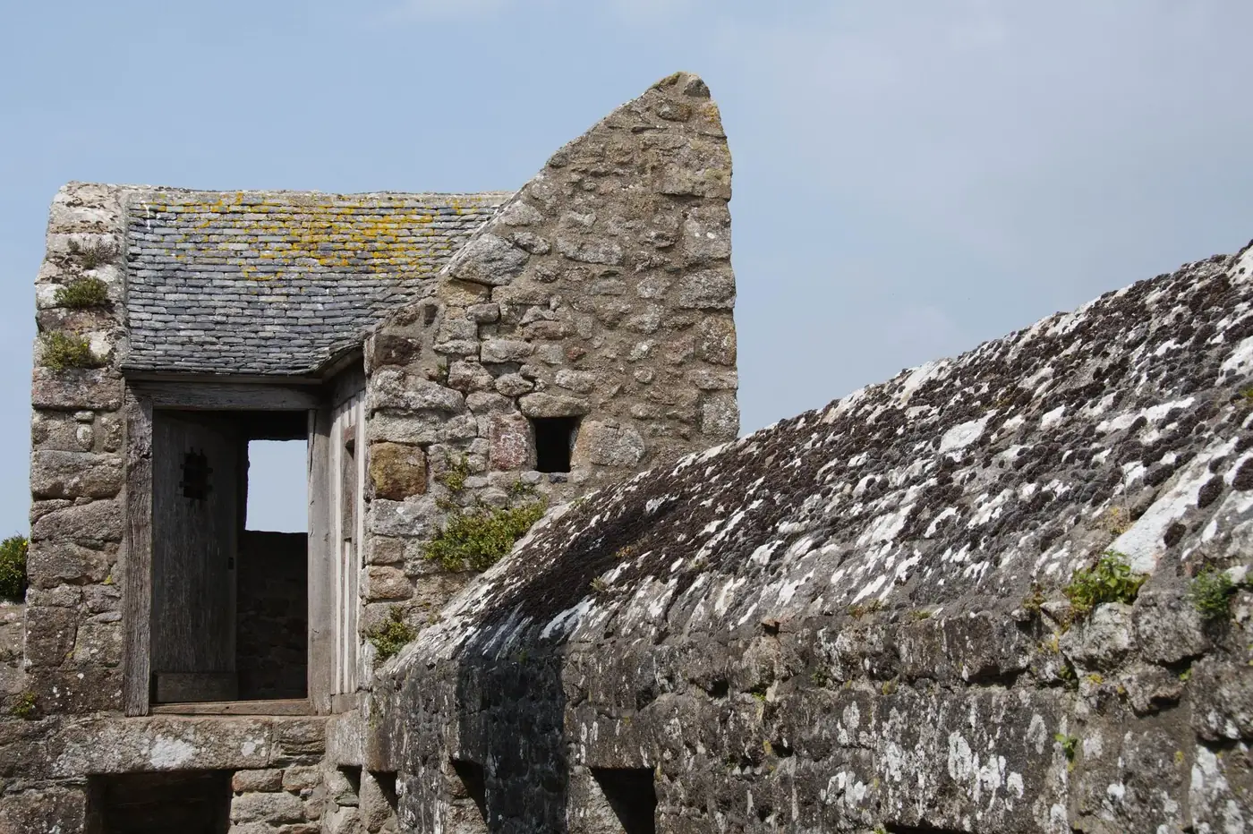 Close-up of a historic stone building with weathered textures in Brittany, France.