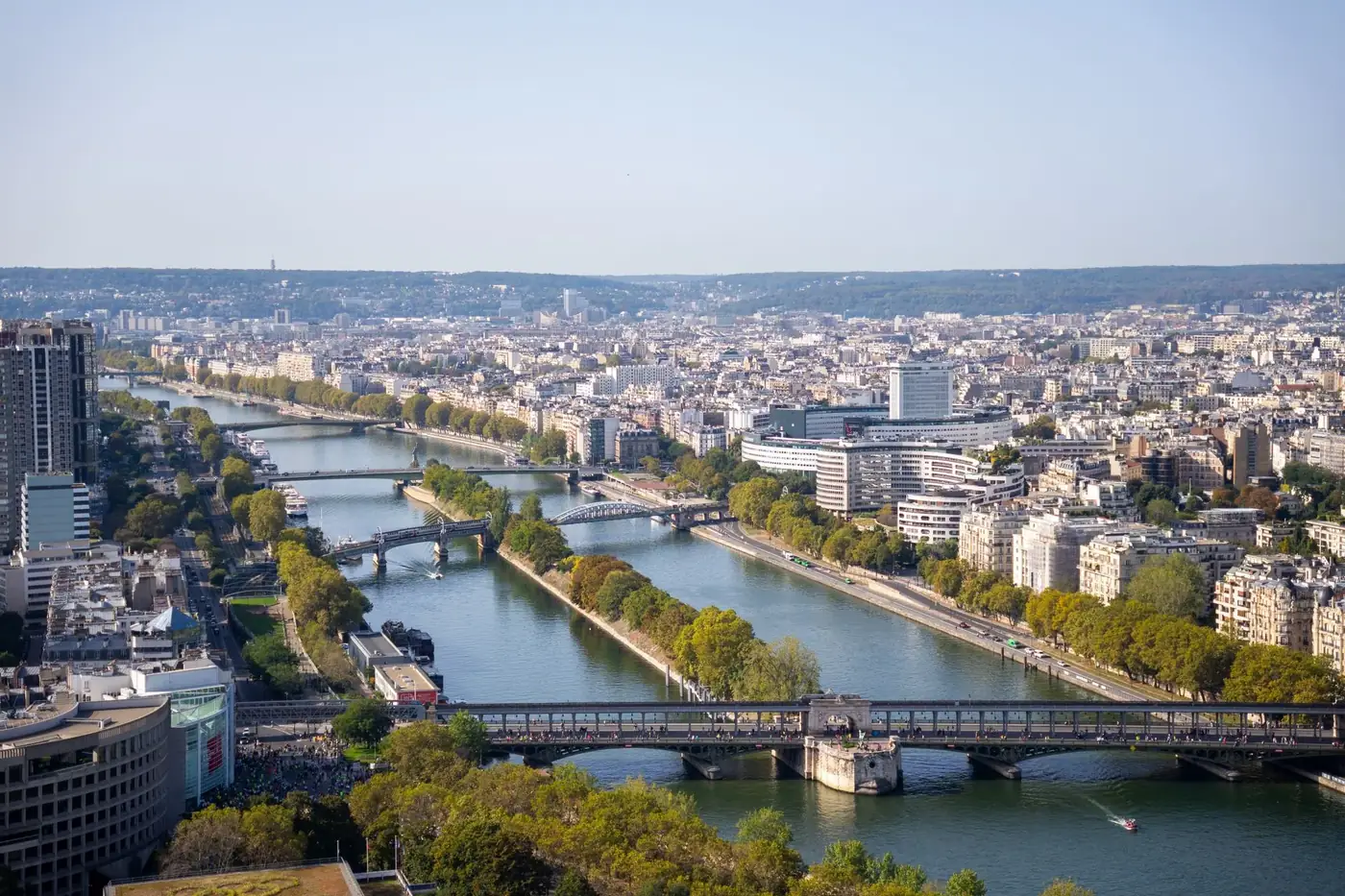 A panoramic aerial view capturing the Seine River and bridges in Paris, France.
