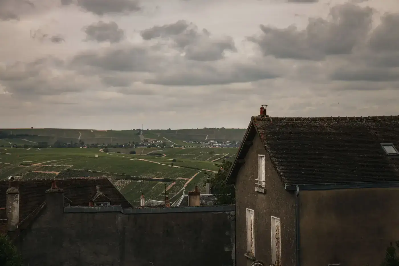 Beautiful view of Sancerre's countryside with vineyards and charming rooftops under a cloudy sky.