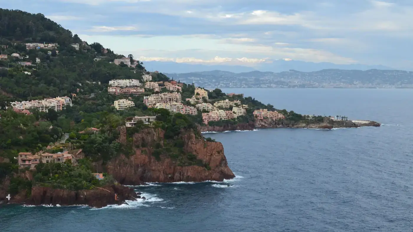 A stunning aerial view of coastal cliffs and buildings along the French Riviera shoreline.