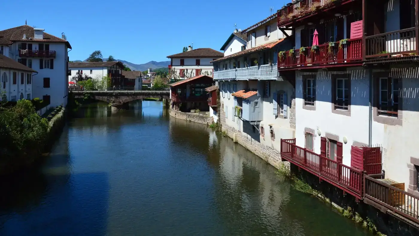 Scenic view of a canal lined with traditional Basque architecture in Saint-Jean-Pied-de-Port, France.