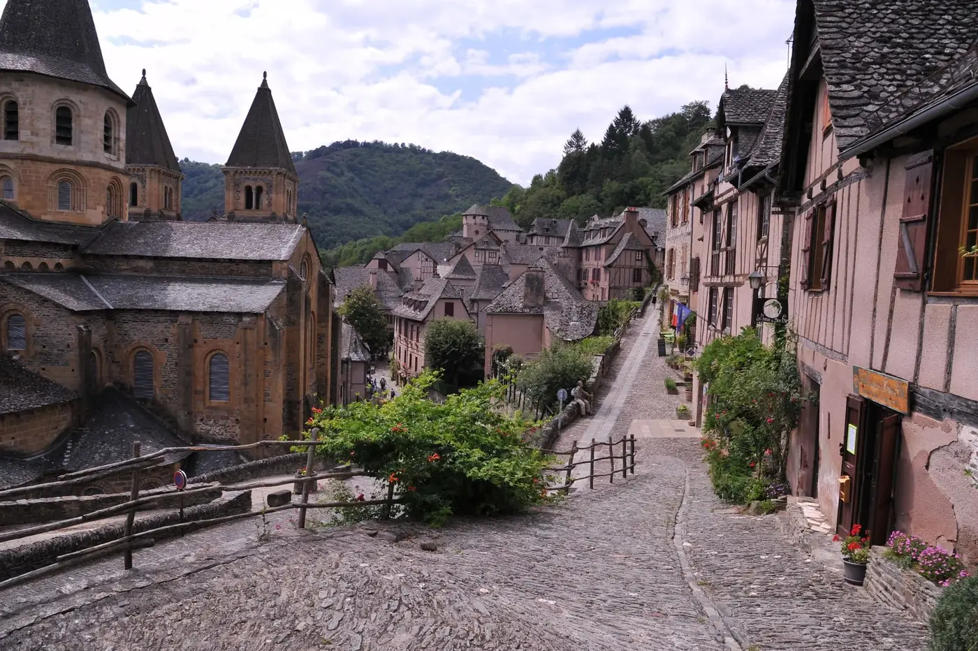 Explore the charm of a picturesque medieval village with historic stone buildings and lush greenery.