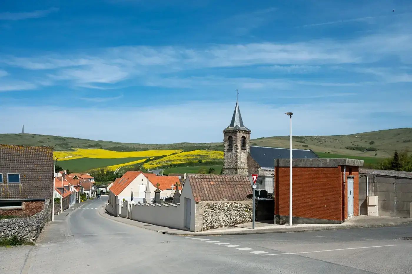 Village scene in Escalles, Hauts-de-France with clear blue skies and countryside landscape.