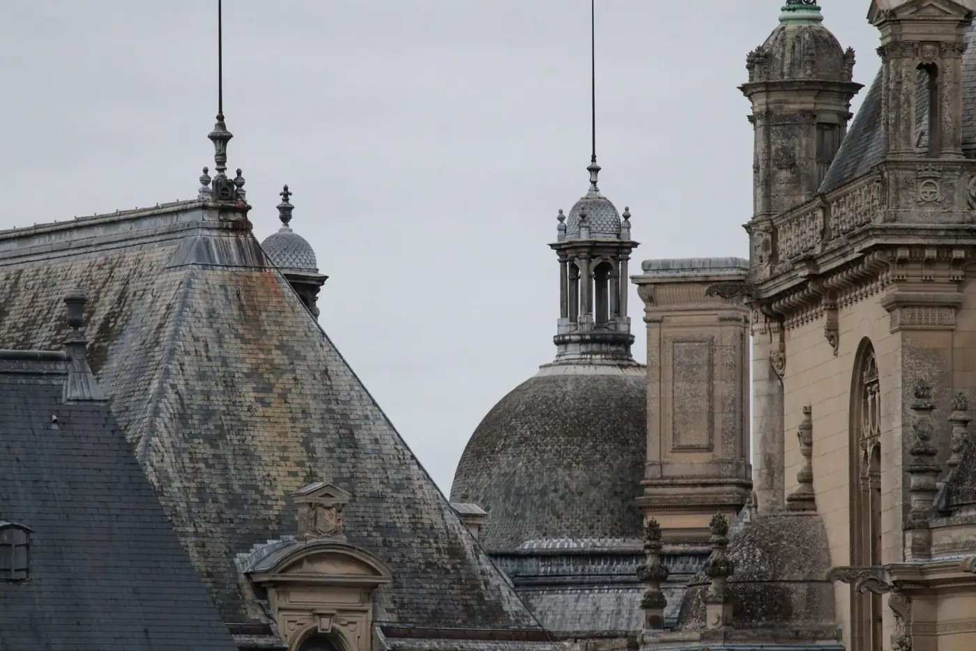 Detail of the iconic Gothic architecture of Château de Chantilly rooftops in France.