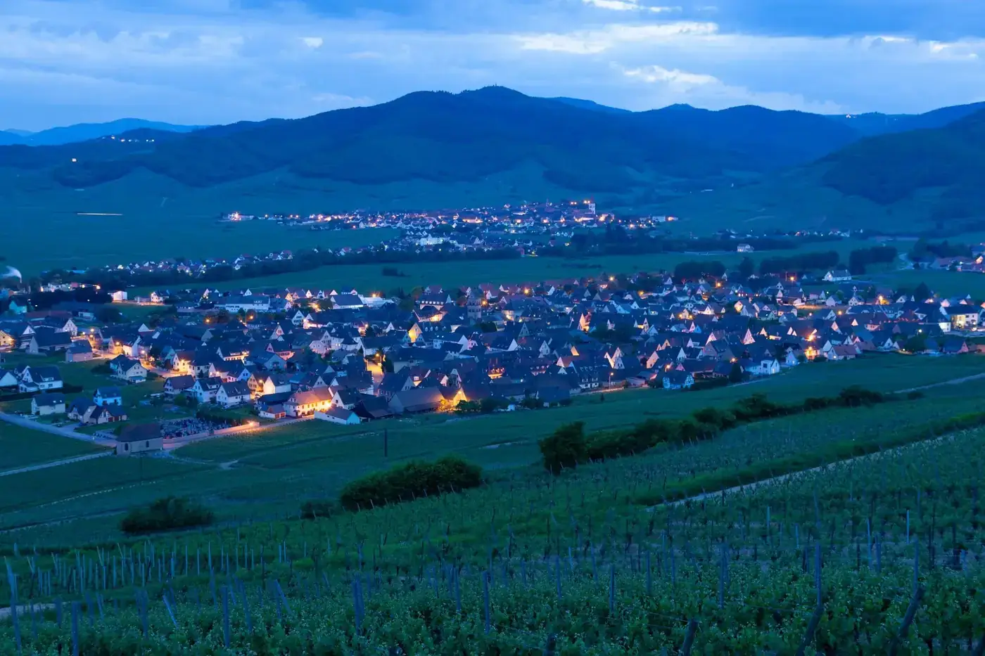 Explore the picturesque vineyard region and evening lights of Mittelwihr village, Grand Est, France.