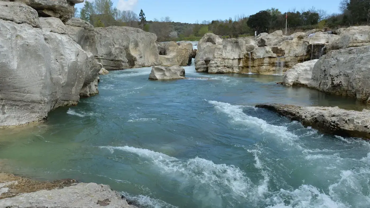 Explore the stunning river landscape in La Roque-sur-Cèze, France, featuring eroded rock formations.