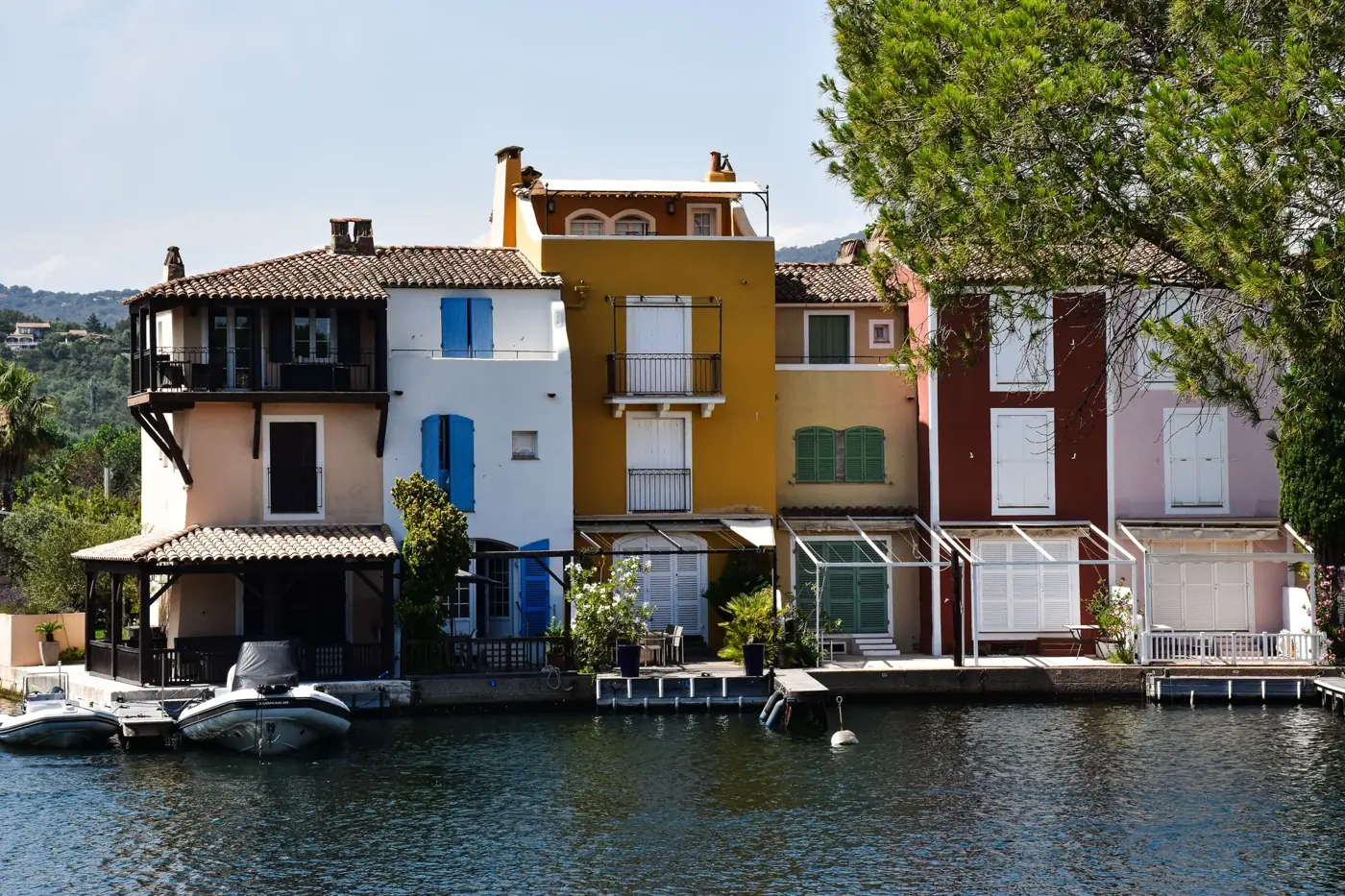 Charming colorful houses by a canal in Provence, showcasing vibrant Mediterranean architecture.