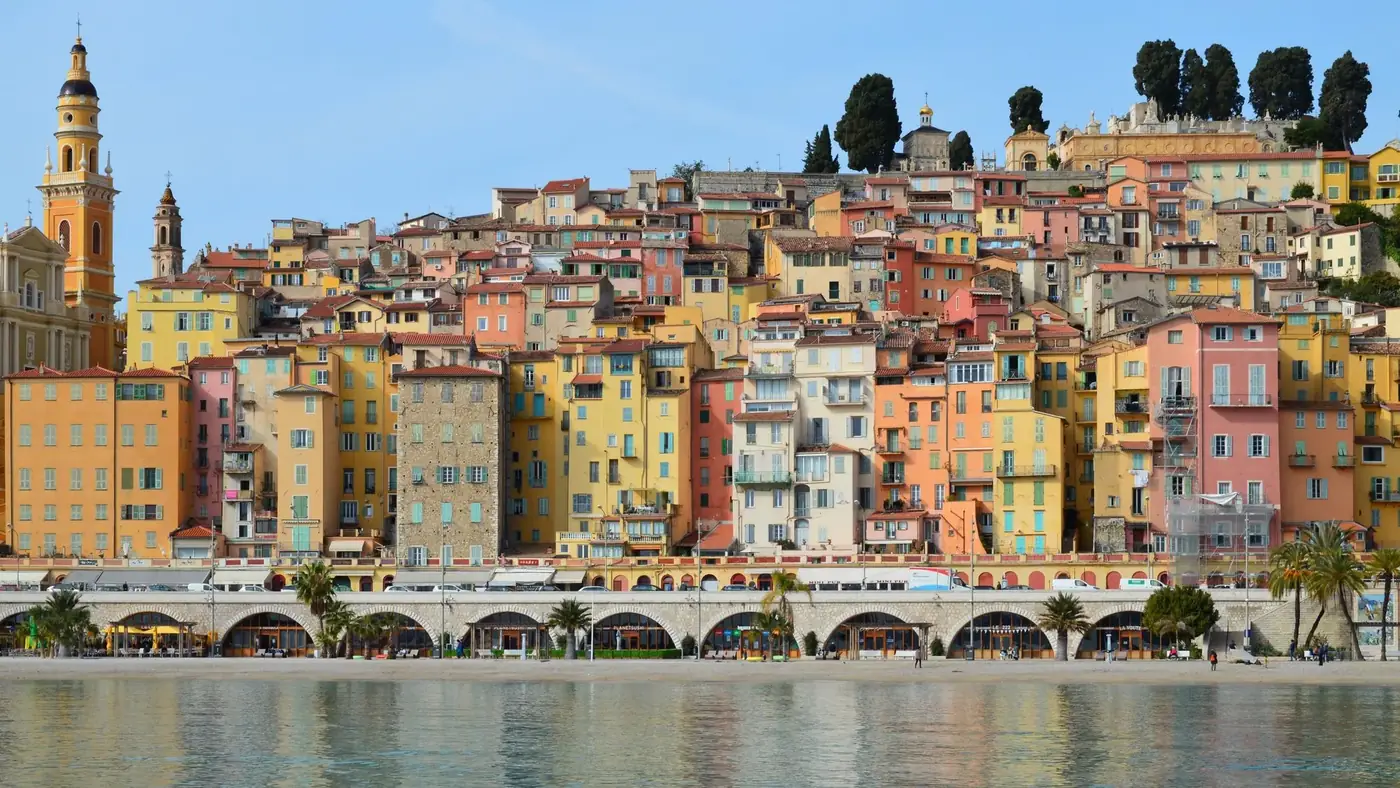 Vibrant coastal town with colorful historic buildings and clear blue sky.