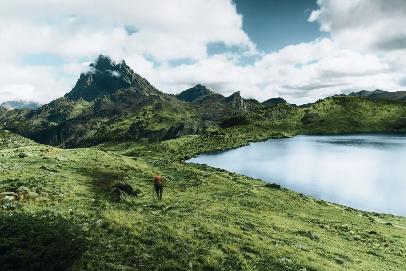 Explore the breathtaking views of the Pyrenees with lush greenery and serene waters.