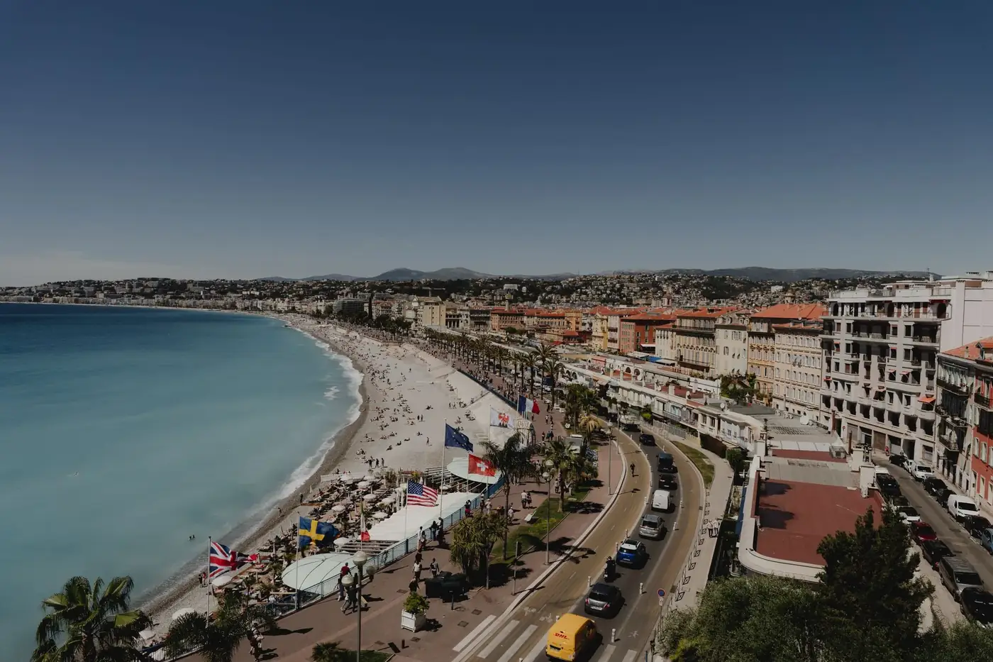 A stunning aerial shot of Nice's coastline and cityscape on the French Riviera under a bright summer sky.