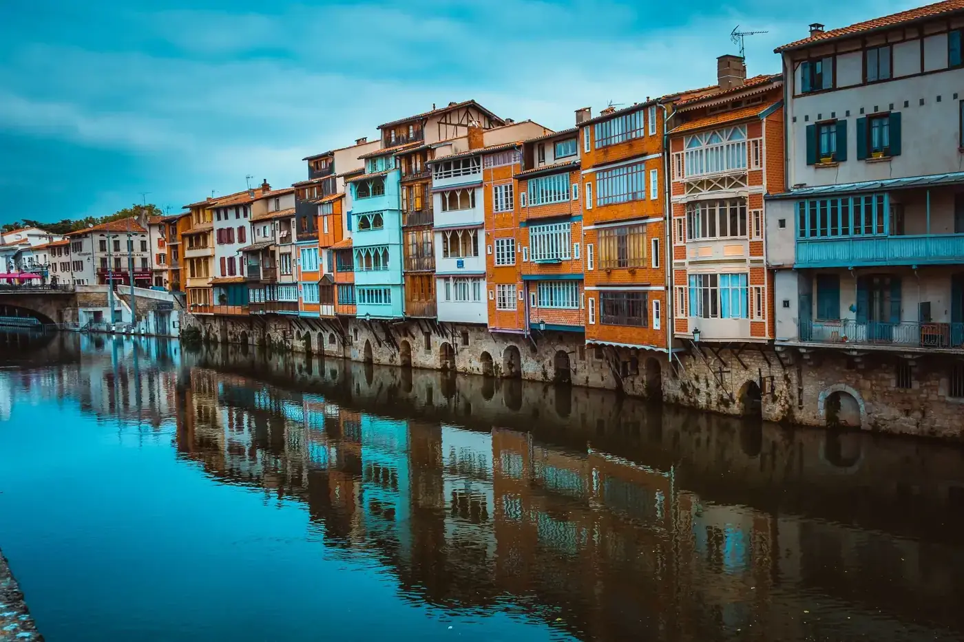 Scenic view of colorful houses reflecting in the river in Castres, France. Perfect for travel and architecture themes.