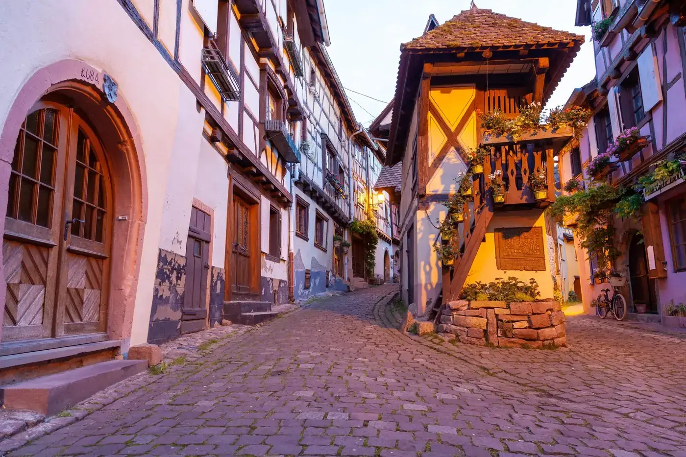 Picturesque cobblestone street in Eguisheim, showcasing traditional Alsatian architecture.