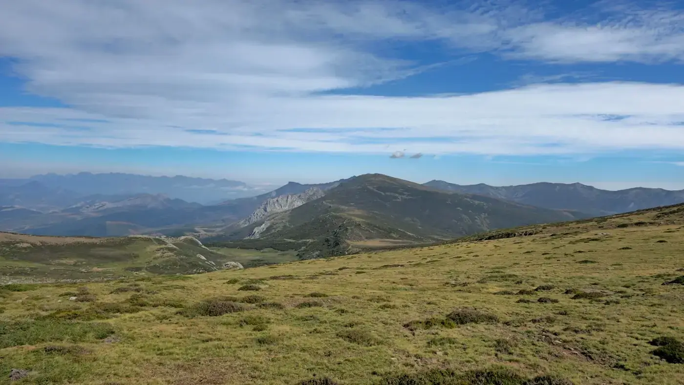 Beautiful aerial view of Le Mont-Dore in spring, showcasing lush forests and snowy mountain peaks.