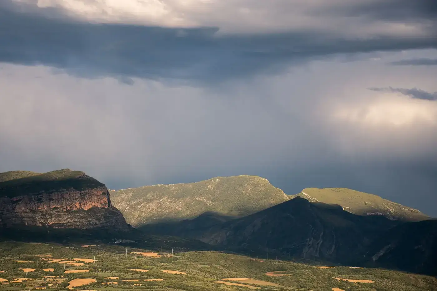 Dramatic aerial view of the Alpine mountains in Mercantour National Park, showing vibrant greenery and rugged peaks.