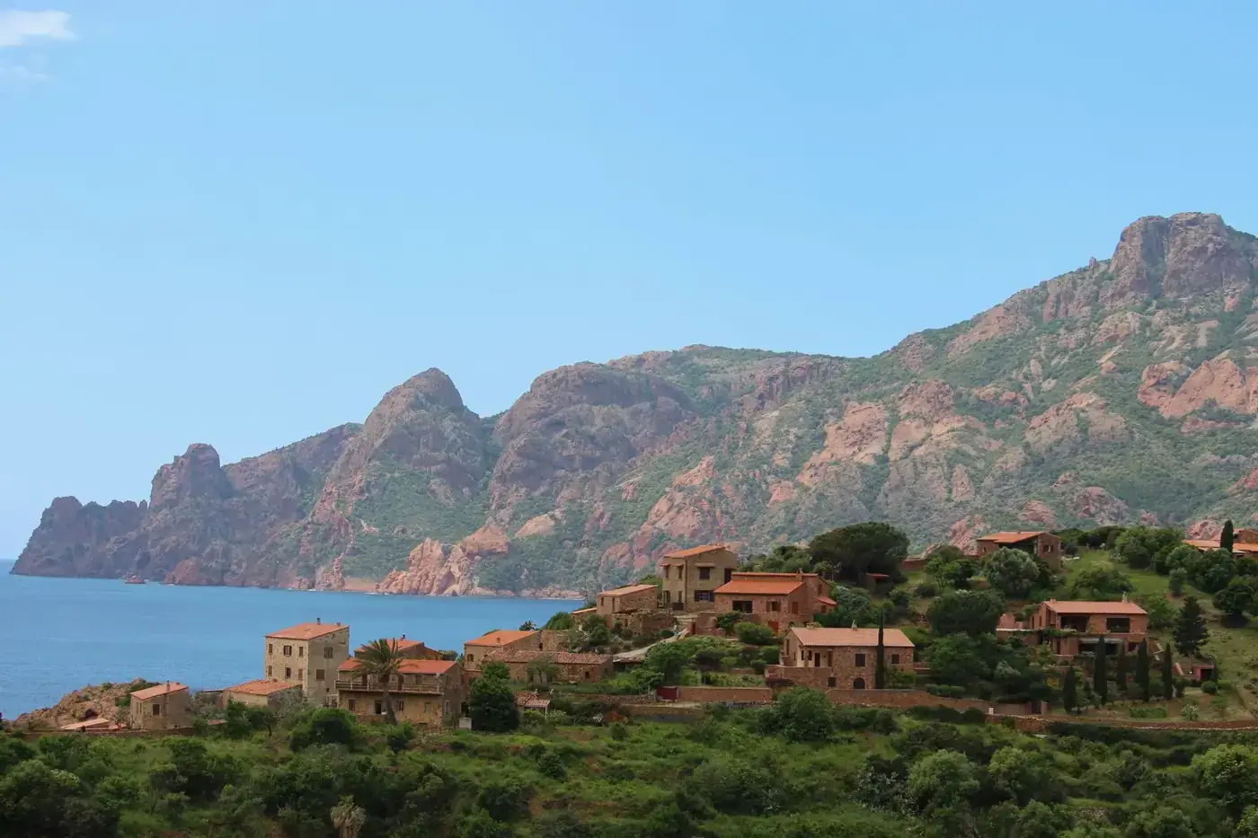 Charming coastal village nestled by the sea with stunning mountain views, perfect for travel inspiration.