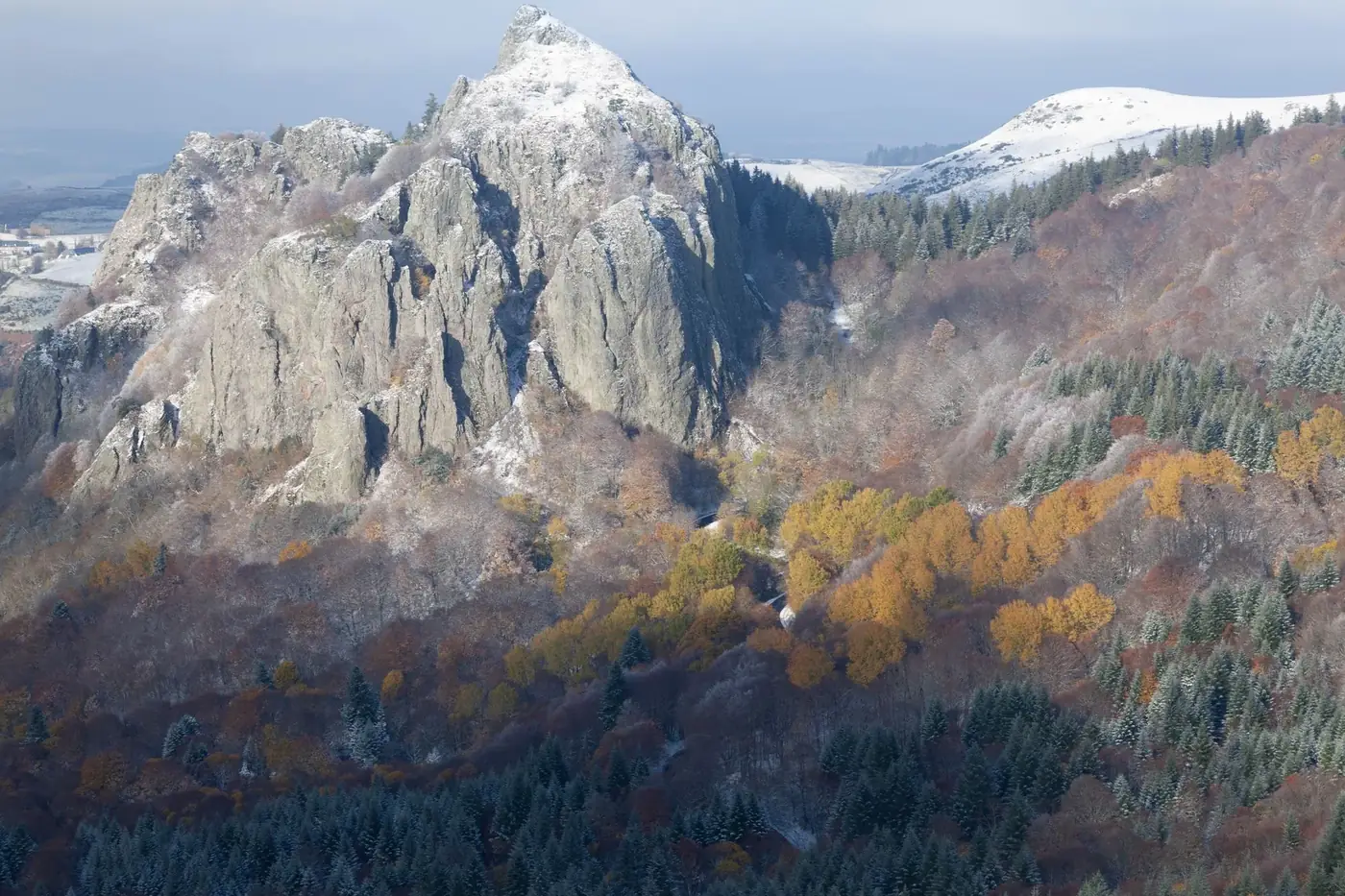 Breathtaking autumn landscape in Le Mont-Dore, featuring snowcapped mountains and colorful foliage.