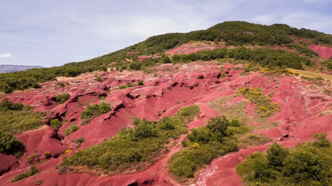 Stunning aerial shot of the red rock hills of Salagou Lake in Occitanie, France.